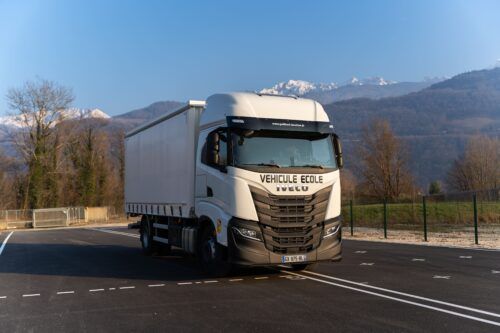 Camion école Iveco S-Way 460 blanc circulant sur la piste d’entraînement d’ALR Formation pour le permis poids lourd C et CE à Grenoble