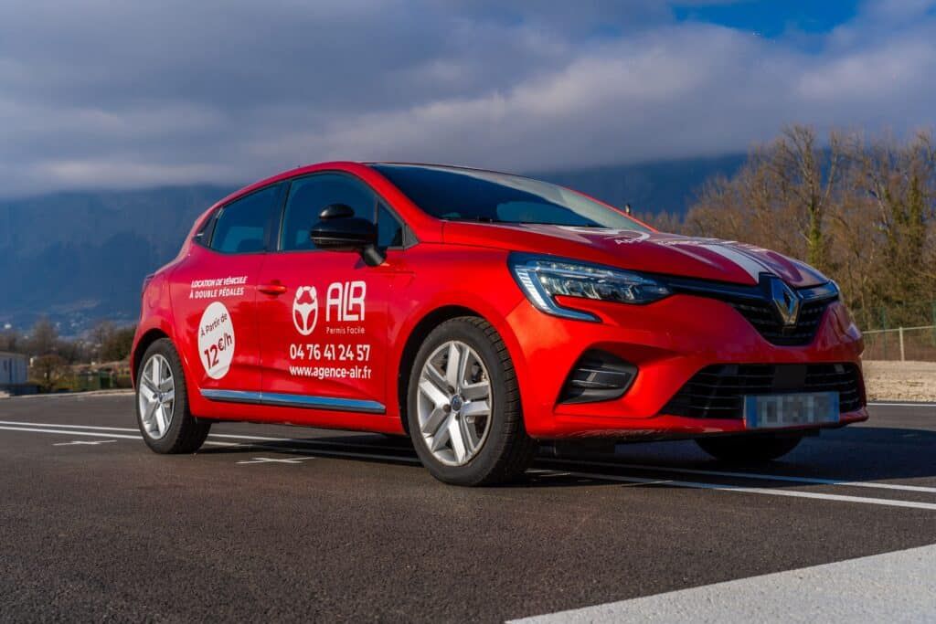 Renault Clio rouge en boîte automatique d’ALR Formation, utilisée pour les heures de conduite à Grenoble